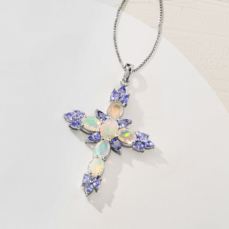 Cross pendant necklace in sterling silver with opal-like center and blue oval gemstones