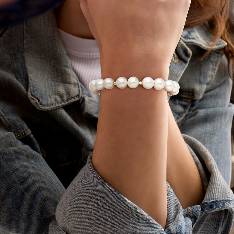 White cultured pearl stretch bracelet worn on wrist with gold accents