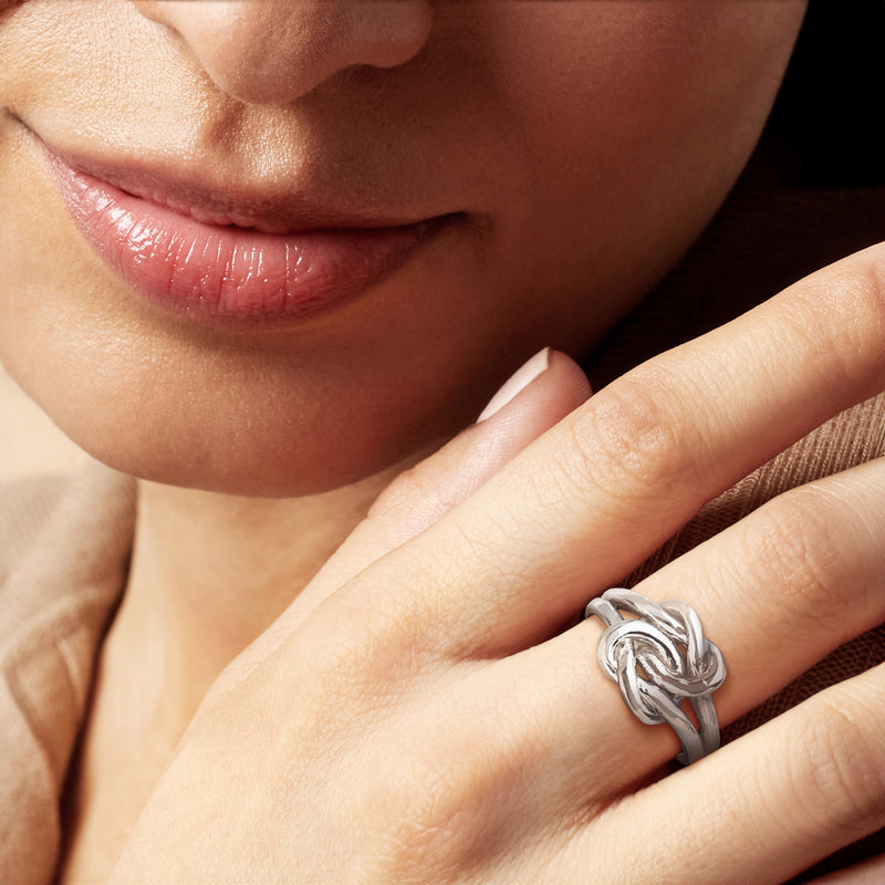 Sterling silver double knot ring worn on finger, braided heart-like loops