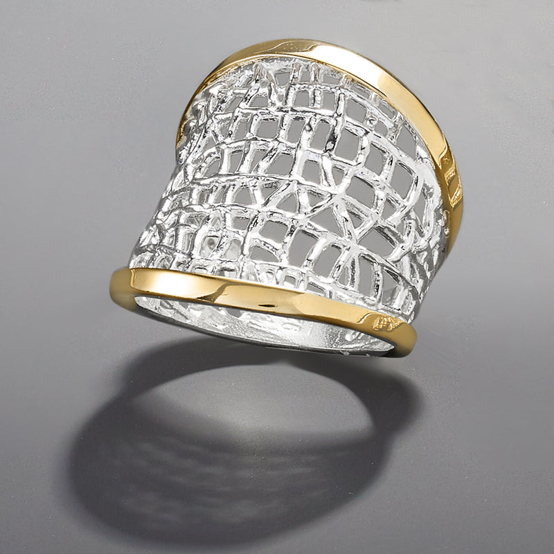 Sterling silver lattice ring with yellow gold top and bottom edges, close-up