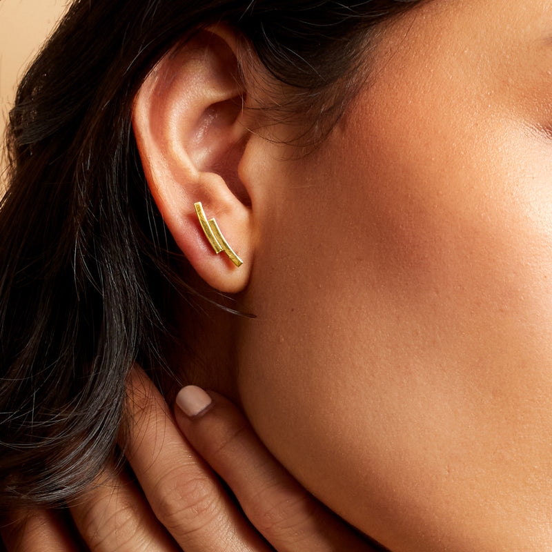 Yellow gold mini double-curve ear climber worn on ear with post earring backing