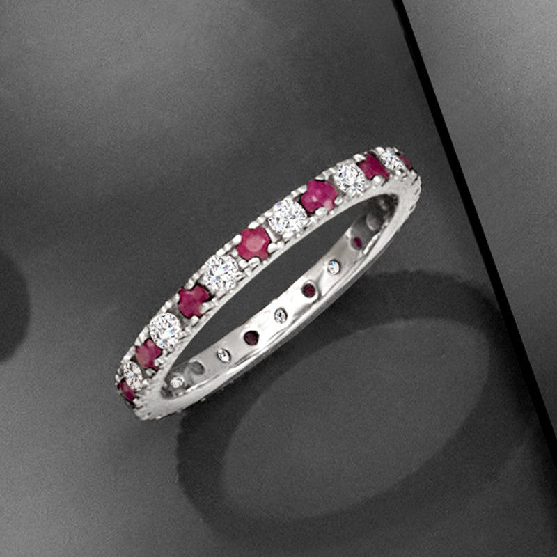 Diagonal view of 14kt white gold eternity band with round pink rubies and diamonds