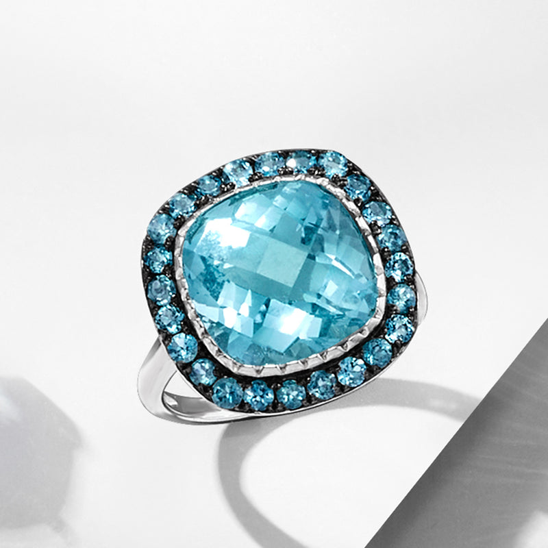 Sterling silver oval blue topaz halo ring, side profile with raised bezel setting