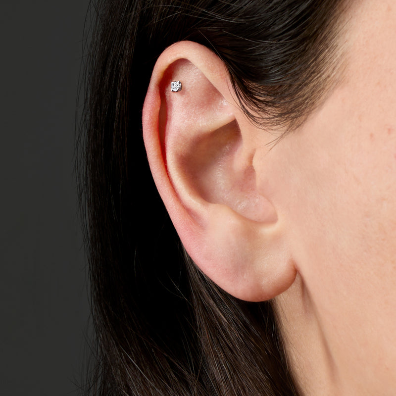 Round diamond stud earring on ear, 14kt white gold setting