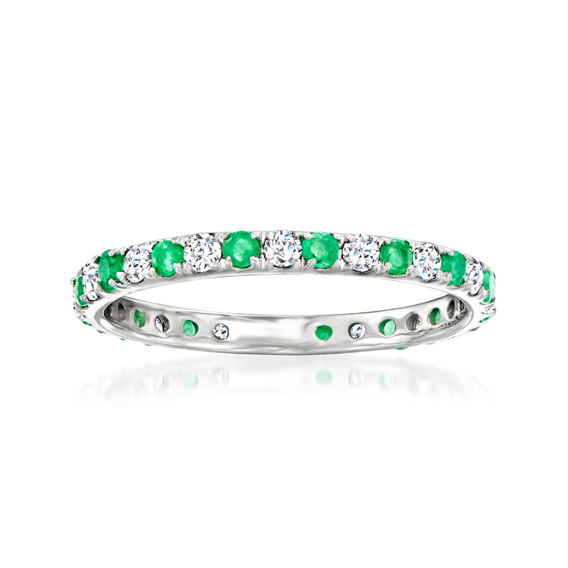 White gold eternity band top view with green emeralds and clear diamond accents