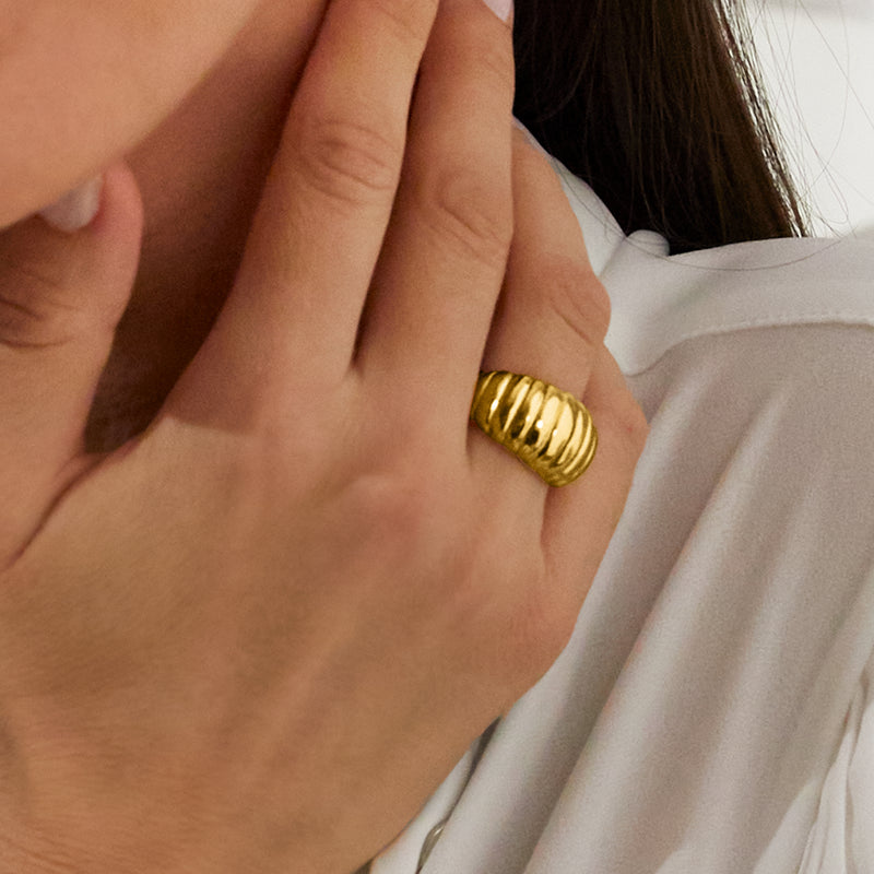 Close-up of hand with 18kt yellow gold ribbed dome ring on finger, vertical ridges