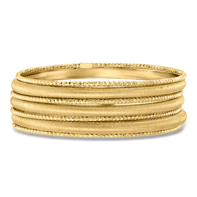 Seven gold over sterling silver bangle bracelets, stacked and textured with smooth bands