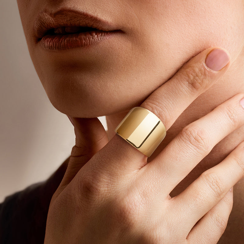 Wide polished 14kt yellow gold ring on hand, smooth squared top