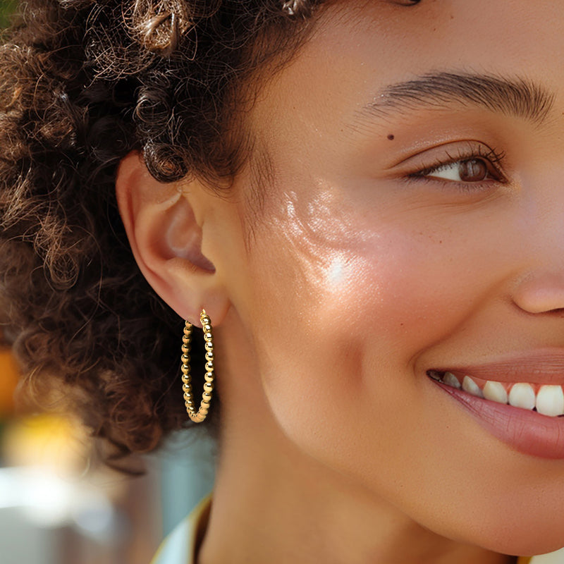 Gold beaded hoop earrings shown on model; small textured hoops with post backs