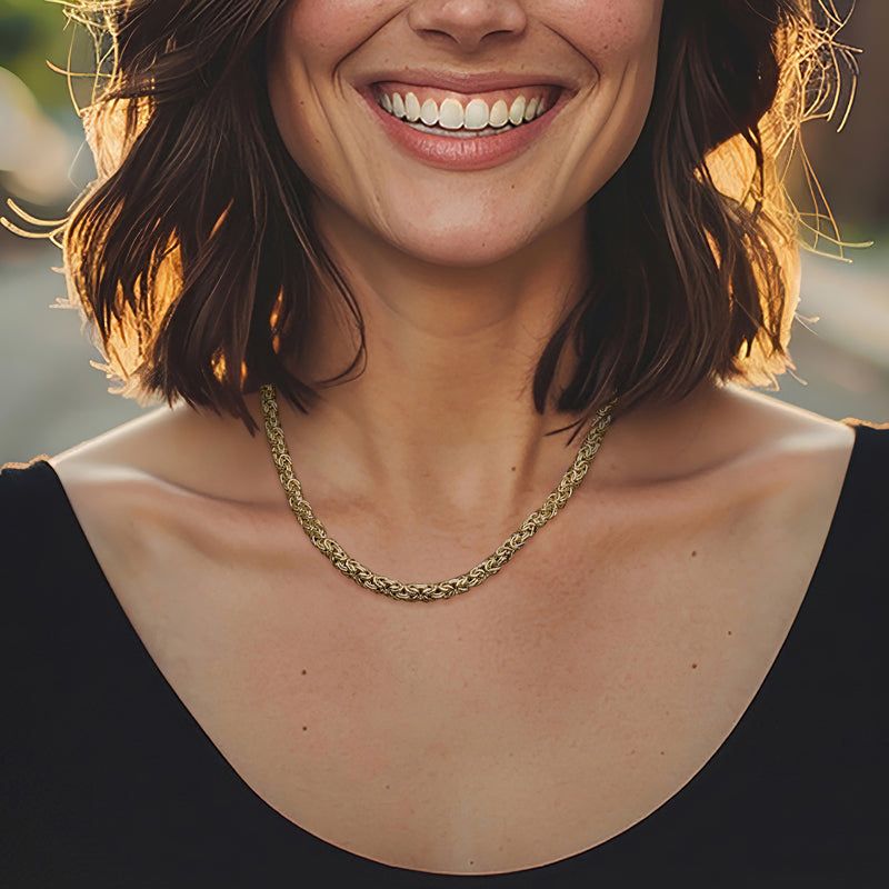 Gold-tone Byzantine chain necklace with curb links, worn at the collarbone