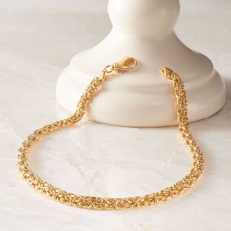 Gold-tone Byzantine chain necklace on a display bust with clasp