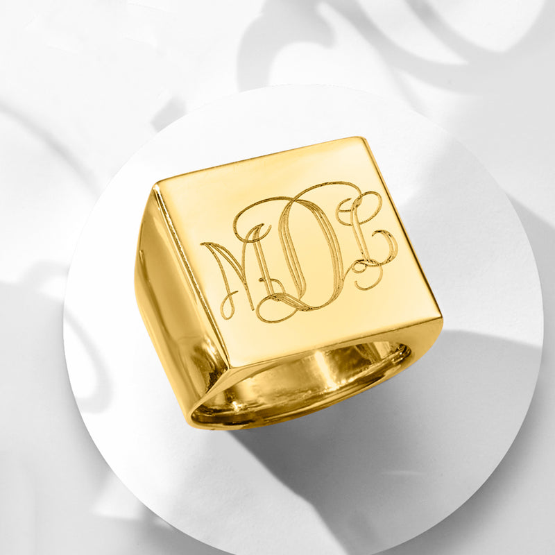 Yellow gold square-top signet ring with engraved monogram, angled view
