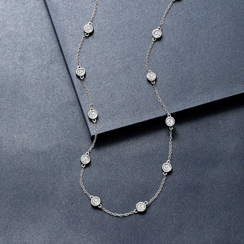 14kt white gold diamond station necklace with bezel-set round stones on a linked chain