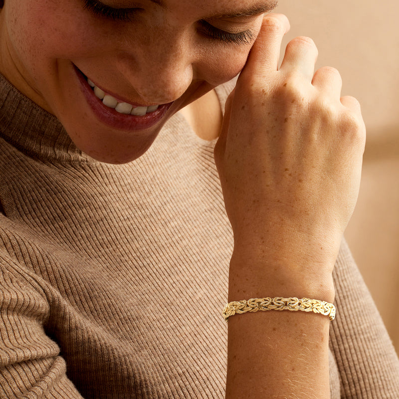 Yellow gold Byzantine bracelet worn on wrist, linked chain with clasp
