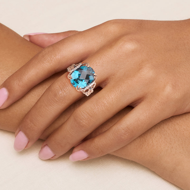 Rose gold blue gemstone ring on hand with white diamond details