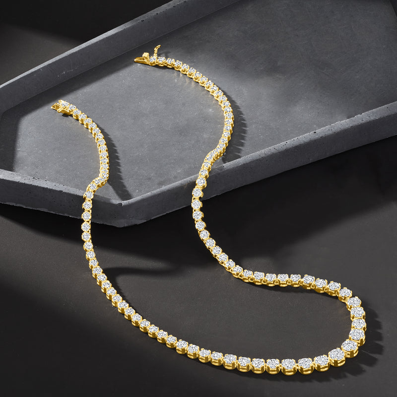Graduated CZ tennis necklace in gold over sterling with round stones, on jewelry tray.