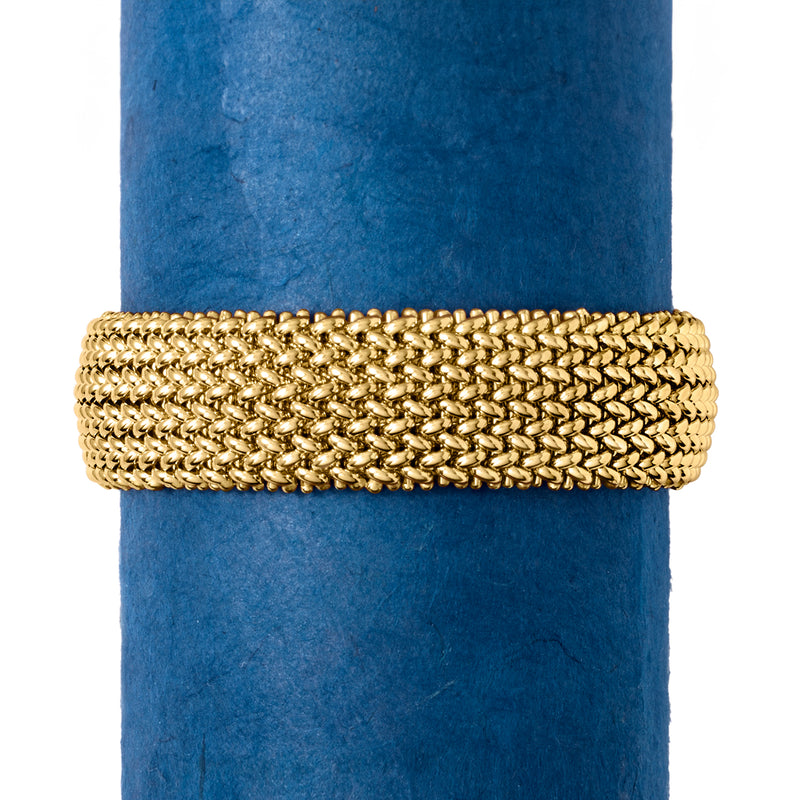Yellow gold wide link bracelet worn on a blue display rod