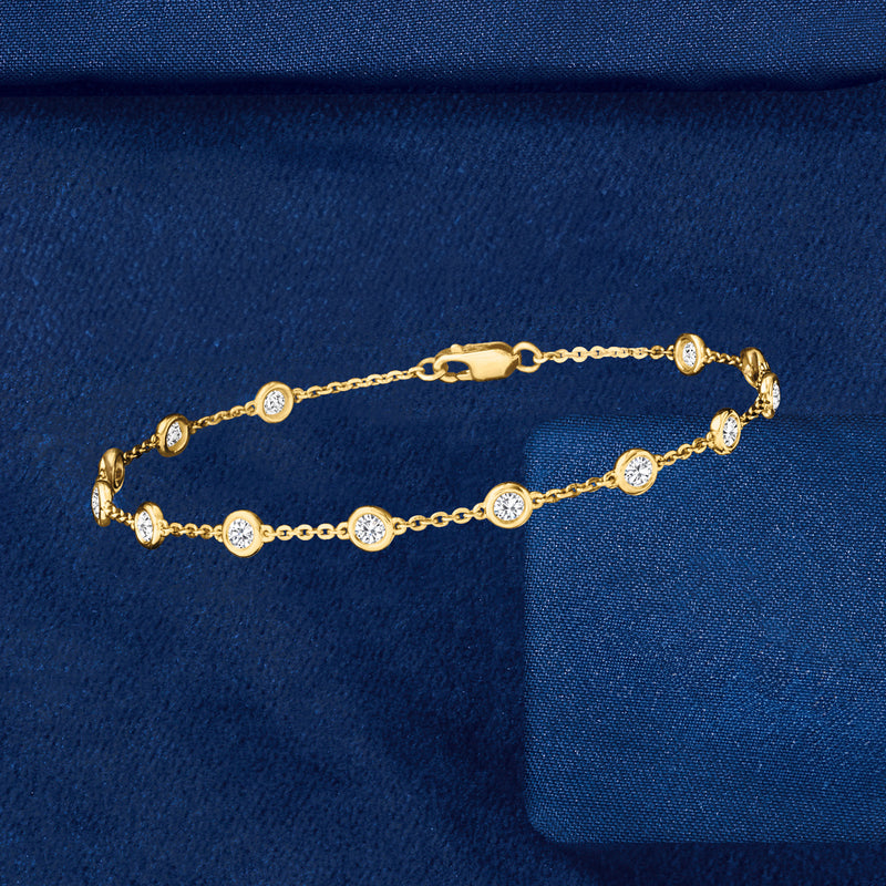 14kt yellow gold diamond station bracelet with round bezel-set stones and clasp