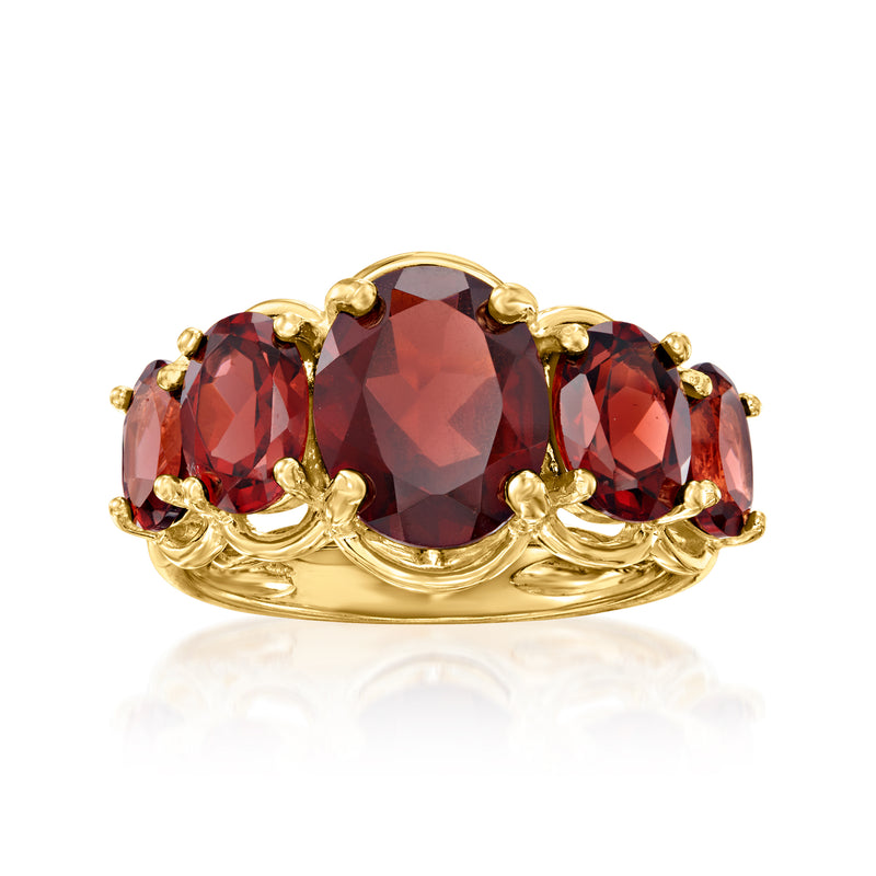 Five-stone garnet ring in gold-tone with oval dark red gemstones and ornate prongs