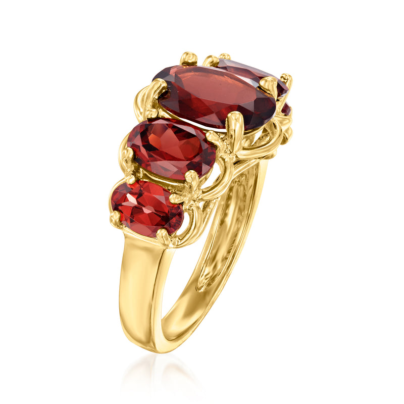 Five-stone garnet ring side view with dark red gemstones in gold-tone curved settings