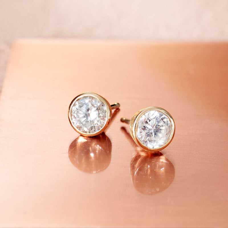 Round diamond stud earrings with 14kt yellow gold bezel-set settings