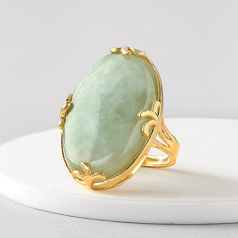 Oval jade ring with gold-tone leaf accents along the band