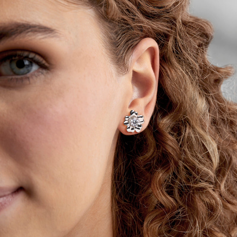 White gold flower petal earring jacket on ear with round center stone