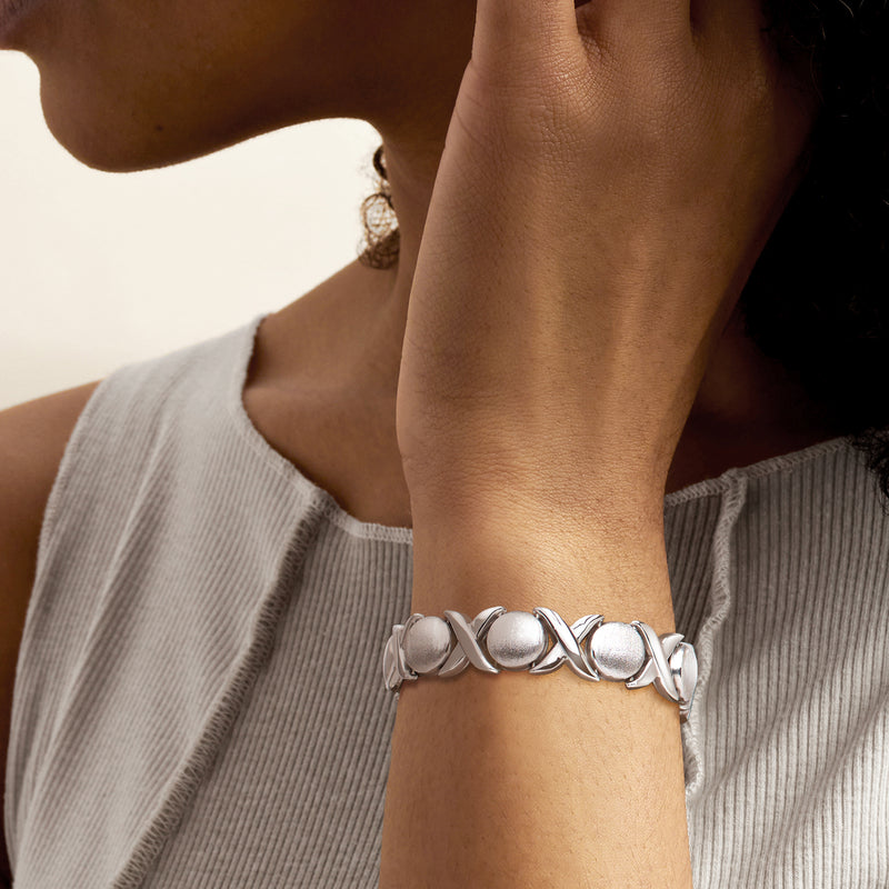 Sterling silver XO-link bracelet on wrist with brushed oval accents and polished metal loops