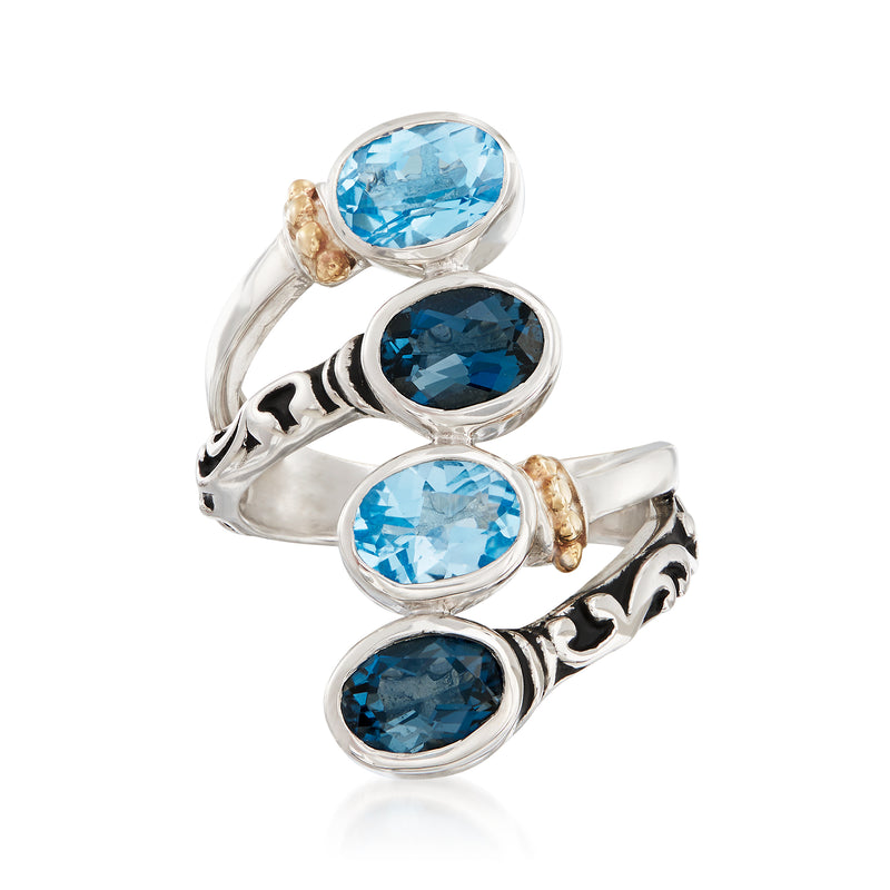 Sterling silver bypass ring with oval blue topaz stones and gold-tone bezels