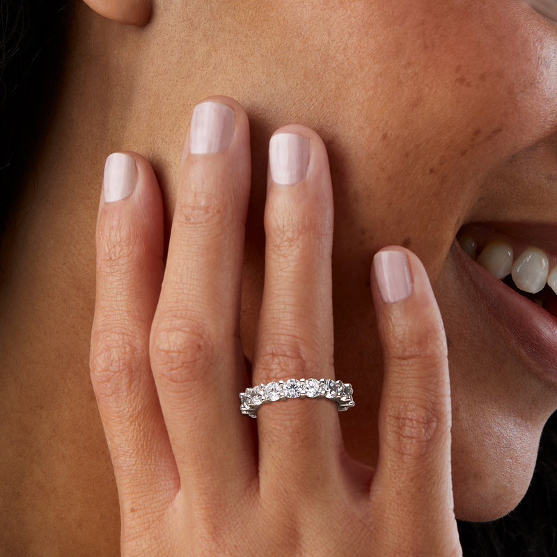 Sterling silver CZ eternity band on finger, row of round stones