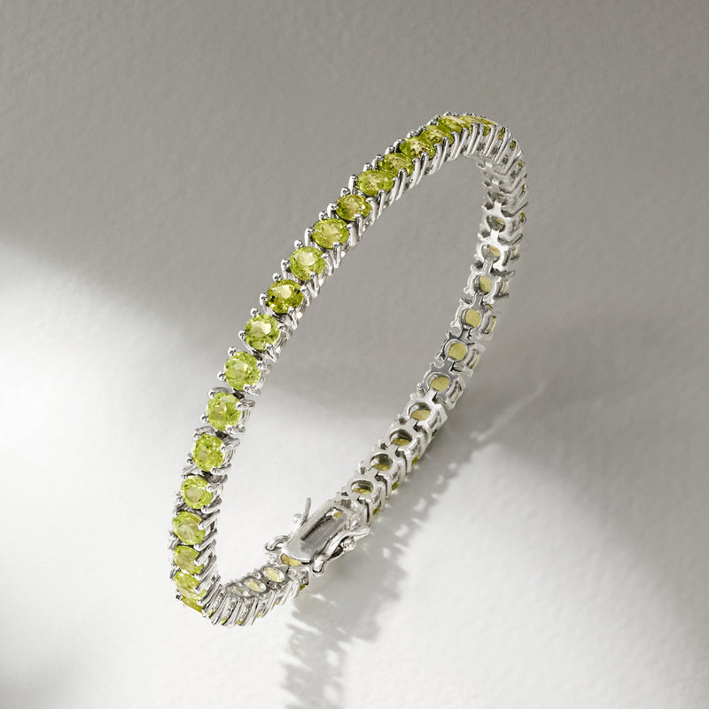 Sterling silver peridot tennis bracelet angled view, round green stones with clasp