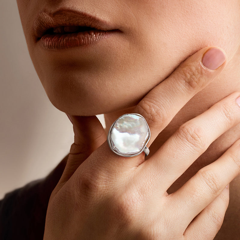 Sterling silver keshi pearl ring on hand, featuring iridescent white irregular pearl