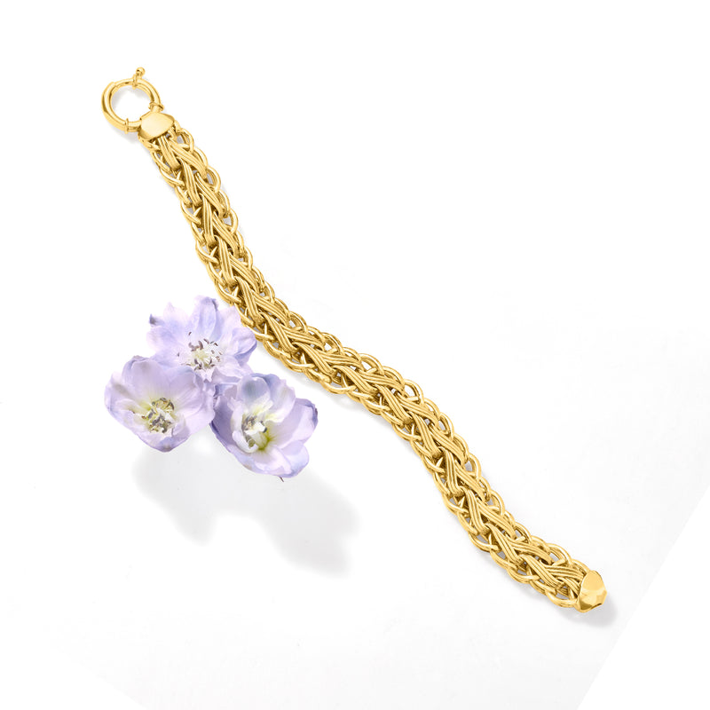 Gold woven-link bracelet with small floral charm and tapered end