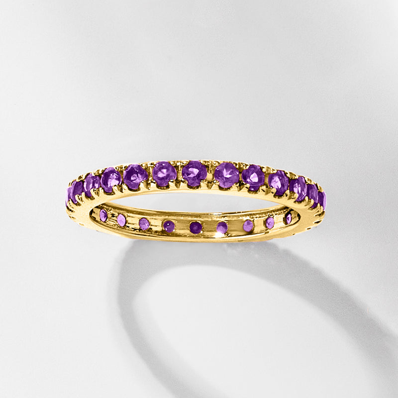 14kt yellow gold amethyst eternity band with a row of round purple stones across the top