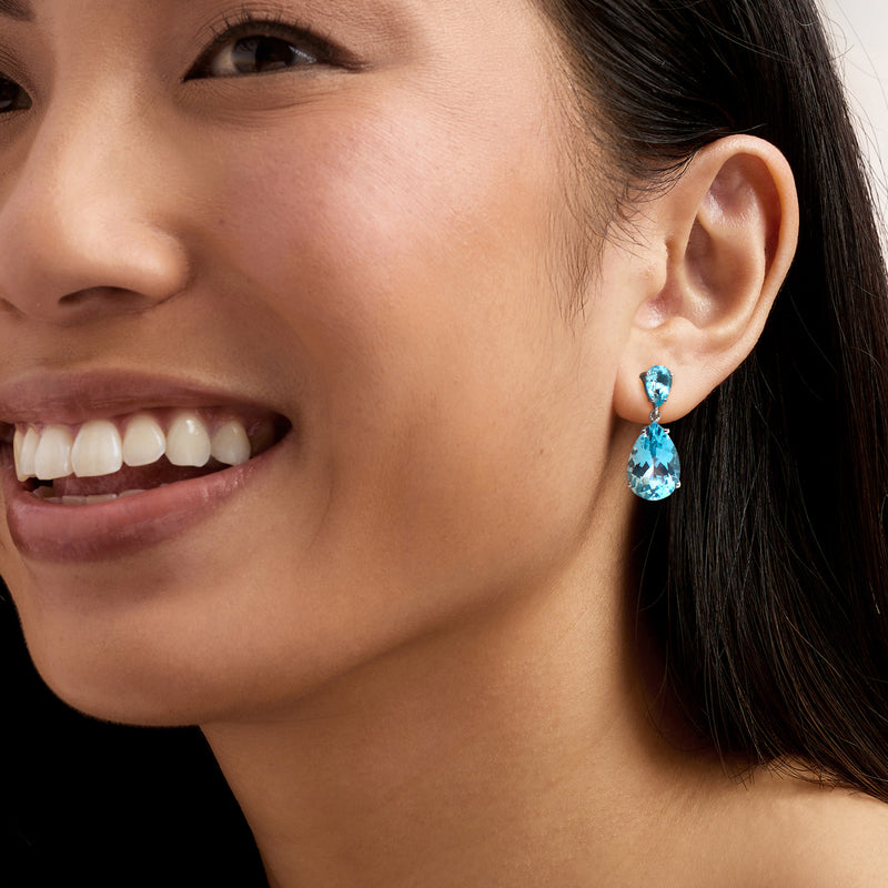 Sterling silver sky blue topaz drop earrings on model, pear teardrop stones