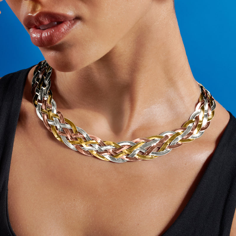 Two-tone braided herringbone collar necklace worn close-up, gold-and-silver chain links.