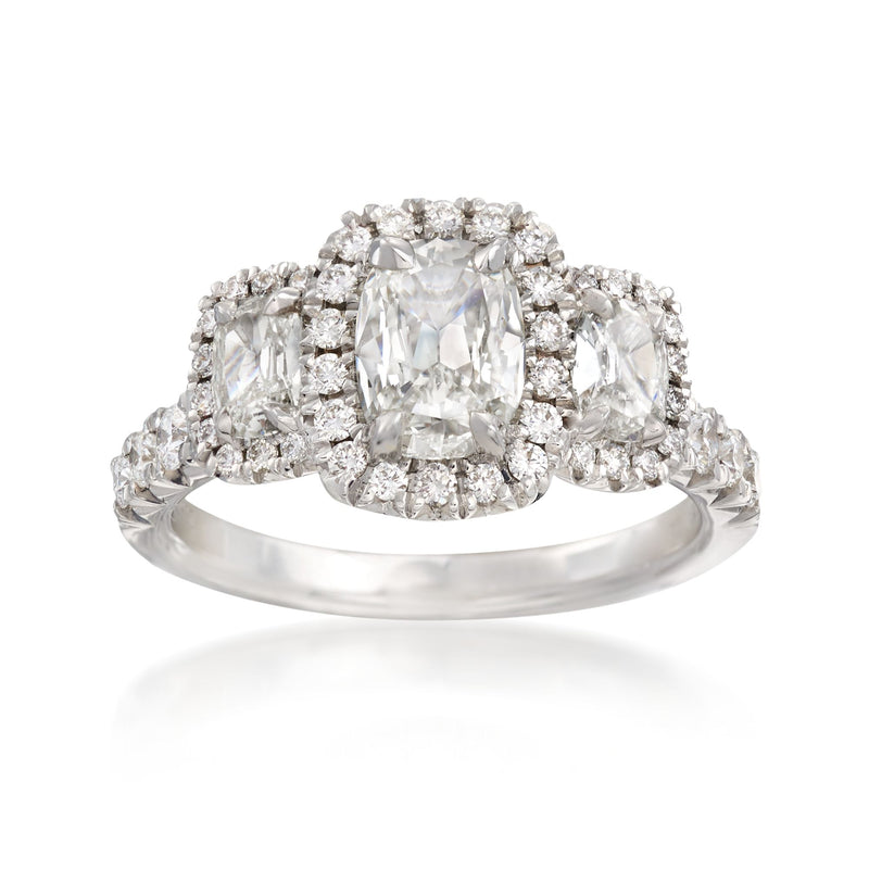 Three-stone diamond engagement ring in 18kt white gold with diamond halos