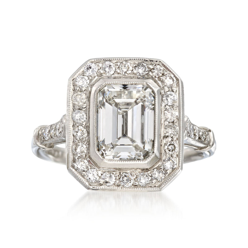 Platinum diamond ring with emerald-cut center, halo of round stones