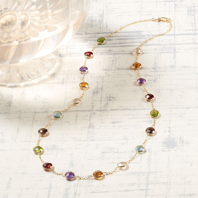 14kt yellow gold station necklace with bezel-set multicolor gemstones, clasp visible