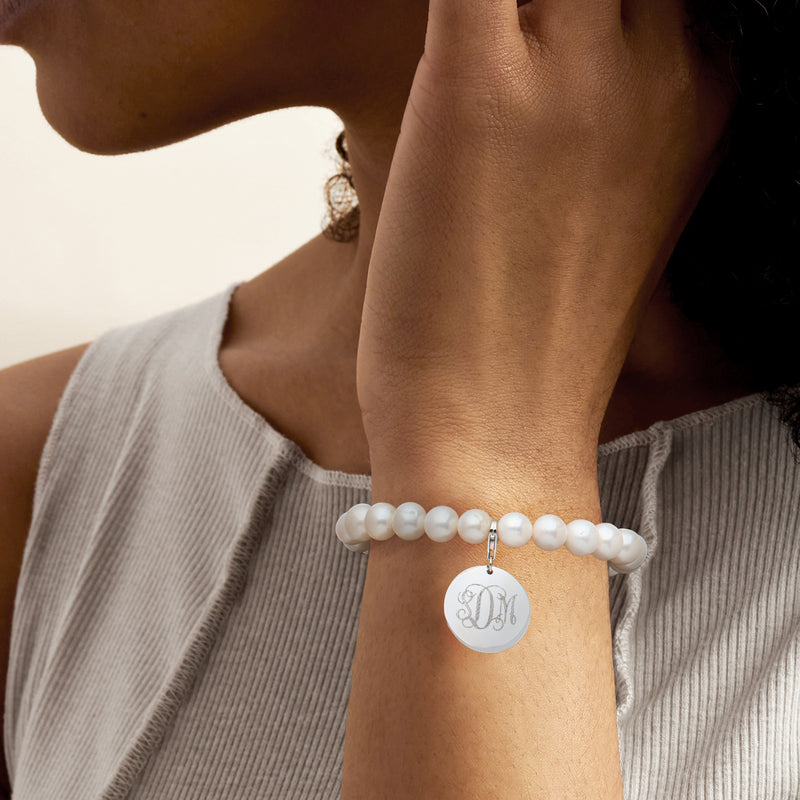 Cultured pearl bracelet on wrist with sterling silver monogram disc charm