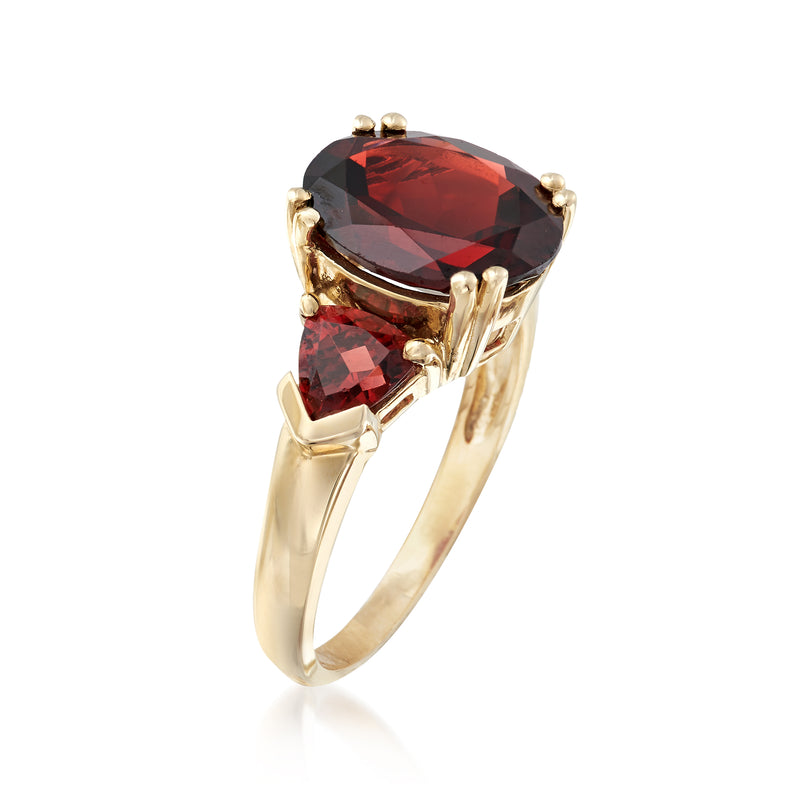 14kt yellow gold garnet ring with oval dark red center stone and two marquise side stones