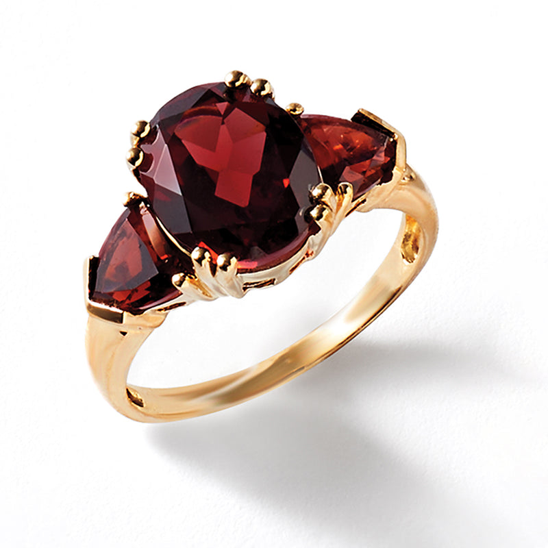 Garnet ring with oval dark red center stone, two marquise side stones, and yellow gold band