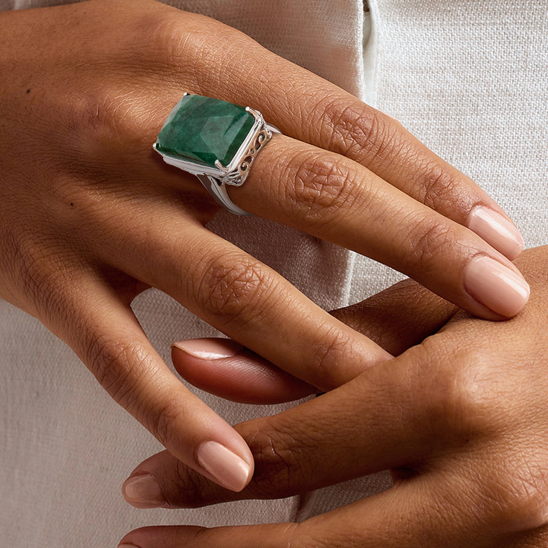 Emerald-cut green gemstone ring in sterling silver on hand, slim band