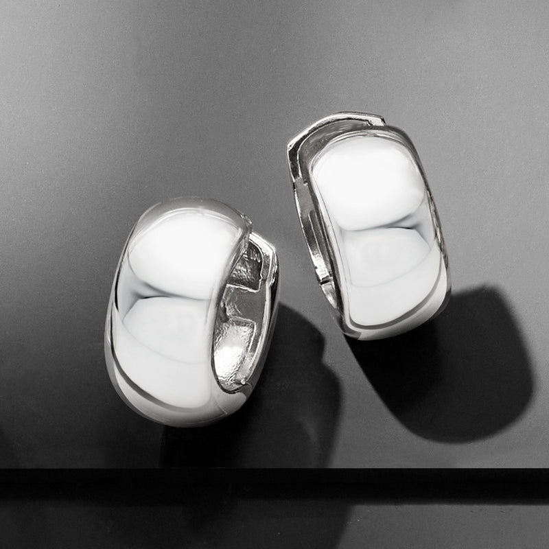 Polished sterling silver huggie hoop earrings, hinged clasp close-up on pair