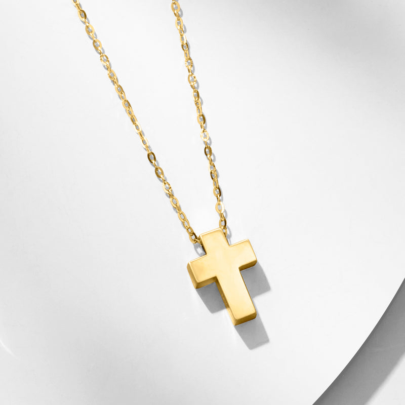 Yellow gold cross pendant necklace with chain and raised cross charm, side angle
