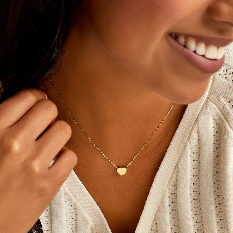 14kt yellow gold heart pendant necklace worn on model's neckline
