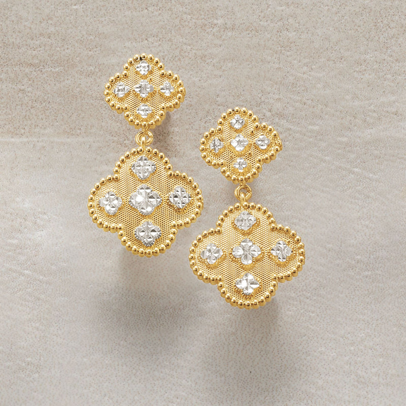 Two-tone gold clover drop earrings with white stone clusters and dangling design
