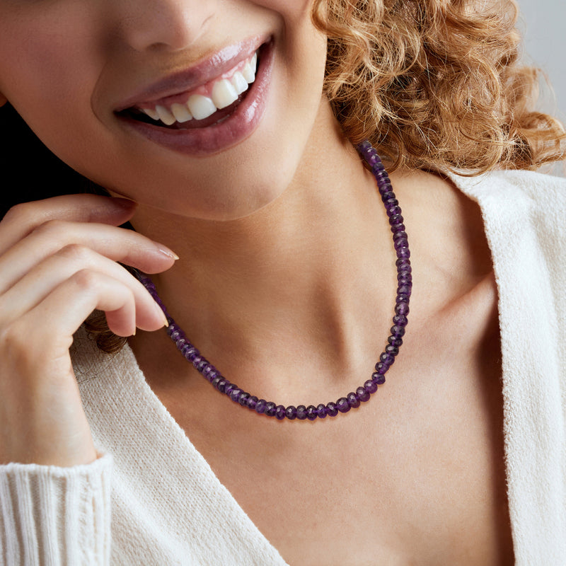 Amethyst bead necklace worn at neckline with round purple beads
