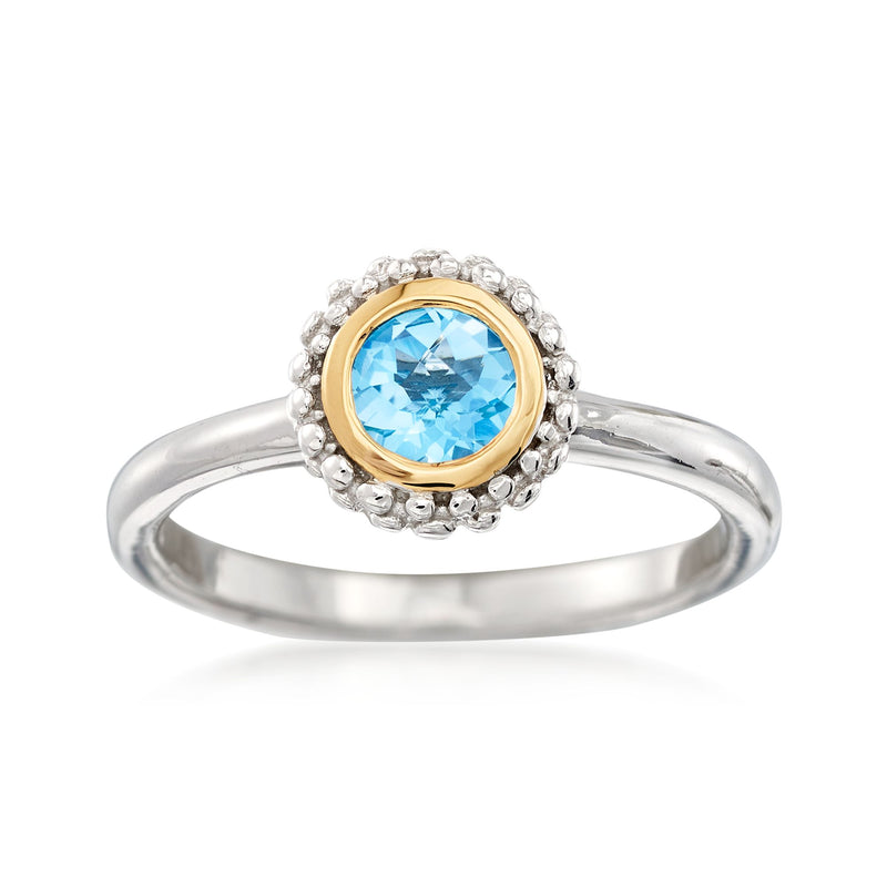 Sterling silver ring with round blue topaz in yellow gold bezel, halo of small clear stones