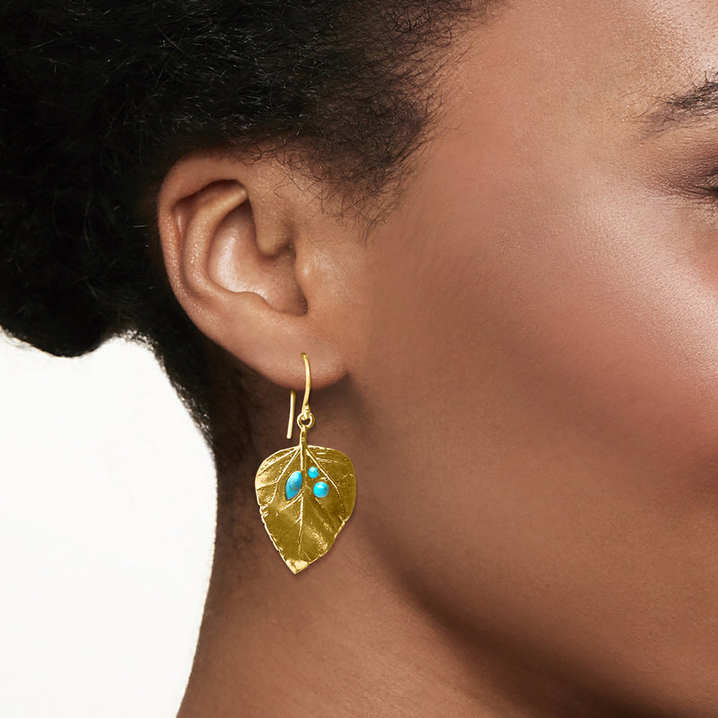 Turquoise-stone gold leaf drop earrings on a model, with earwire
